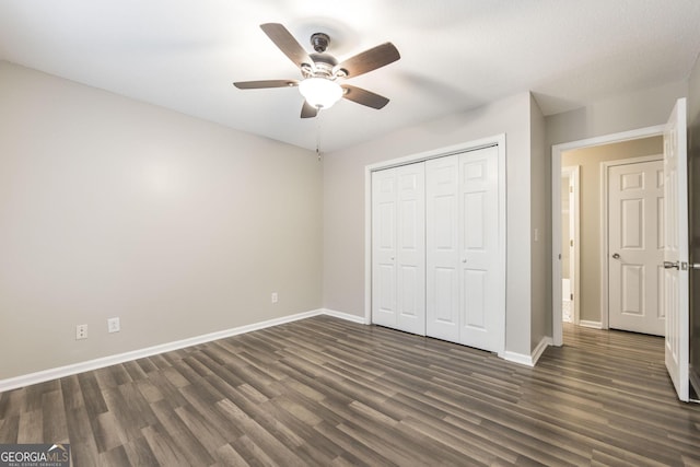 unfurnished bedroom featuring ceiling fan, dark wood-type flooring, and a closet