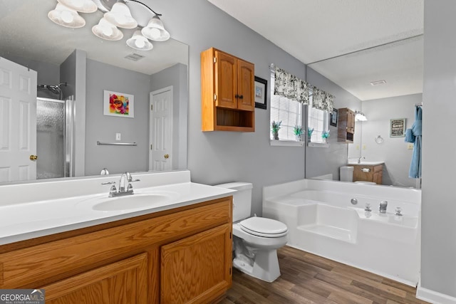 full bathroom featuring toilet, vanity, plus walk in shower, and hardwood / wood-style floors