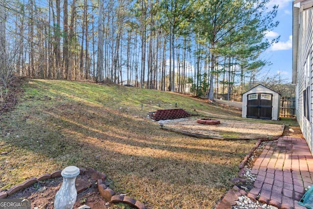 view of yard with an outdoor fire pit and a storage unit