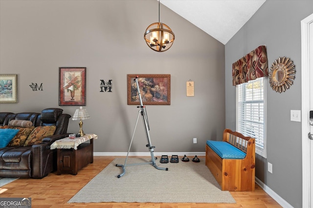 sitting room with lofted ceiling, a notable chandelier, and light hardwood / wood-style flooring