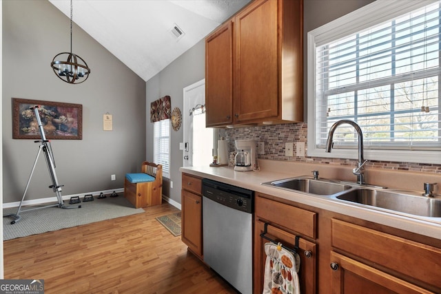 kitchen with stainless steel dishwasher, a healthy amount of sunlight, a chandelier, decorative light fixtures, and lofted ceiling