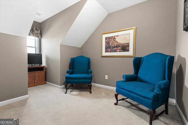 sitting room with a textured ceiling, lofted ceiling, and carpet floors