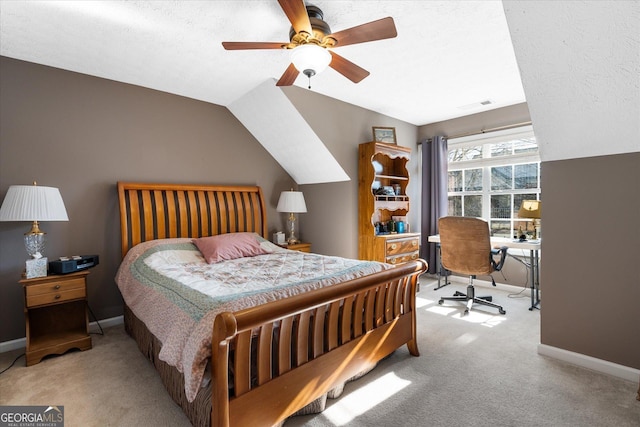 bedroom featuring ceiling fan, vaulted ceiling, light carpet, and a textured ceiling