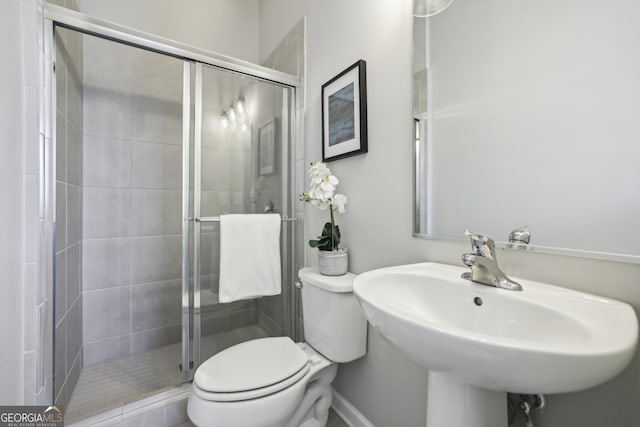 bathroom featuring walk in shower, toilet, and sink