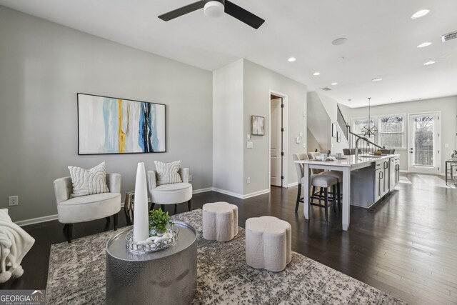 living room with ceiling fan and dark hardwood / wood-style flooring