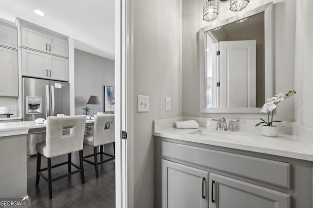 bathroom featuring wood-type flooring, vanity, and backsplash