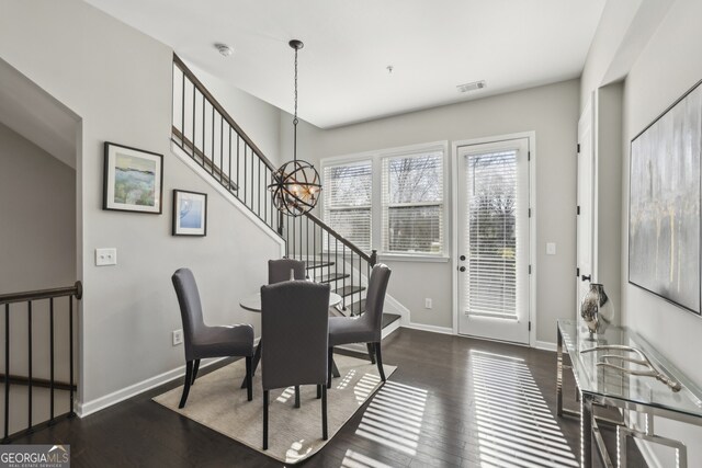 dining area with a notable chandelier and dark hardwood / wood-style flooring