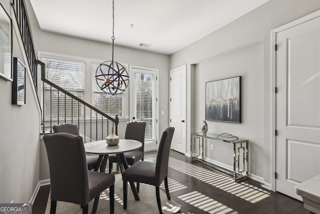 dining room with dark wood-type flooring and a notable chandelier