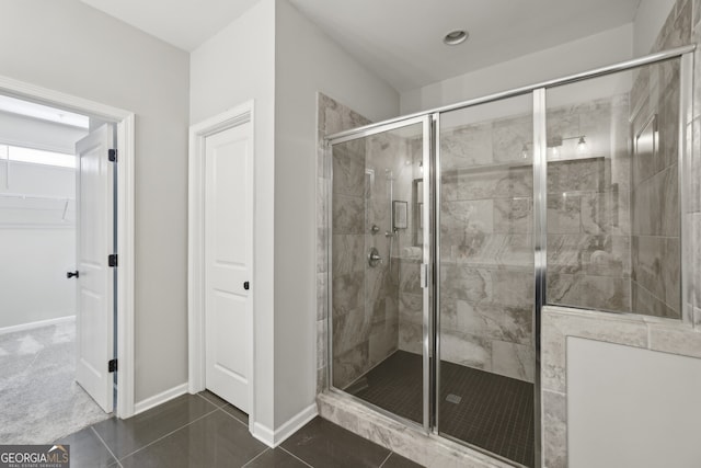 bathroom with tile patterned floors and a shower with door