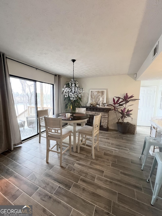 dining space featuring an inviting chandelier and a textured ceiling