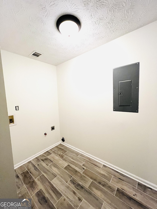 laundry room with washer hookup, electric panel, a textured ceiling, and hookup for an electric dryer