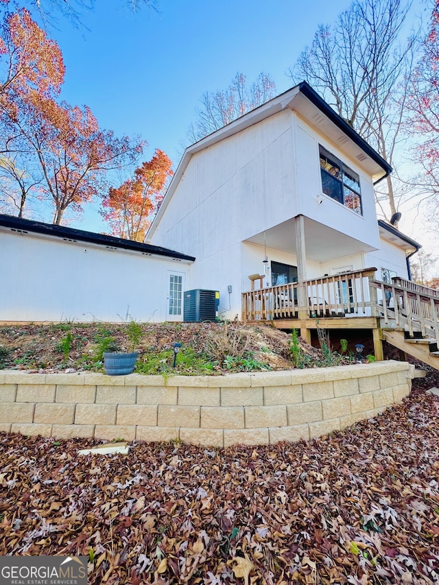 back of property featuring central air condition unit and a wooden deck