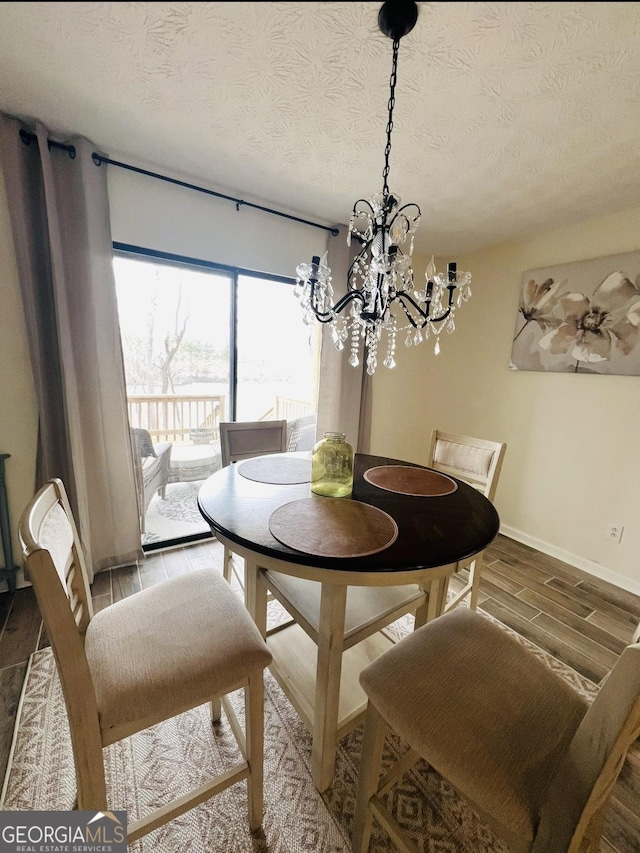 148 N Stewart Ln, Griffin, GA 30224 - dining area featuring wood finished floors, a notable chandelier, and a textured ceiling