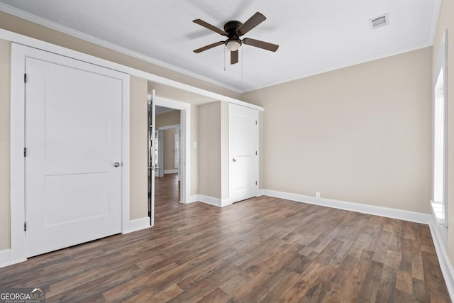 unfurnished bedroom with ornamental molding, dark wood-type flooring, and ceiling fan