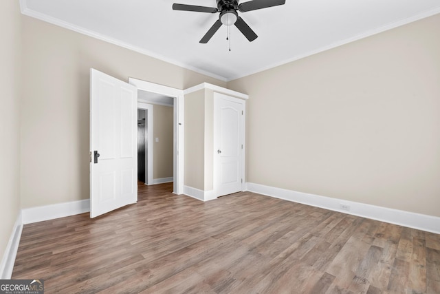 unfurnished bedroom with ceiling fan, crown molding, and hardwood / wood-style floors