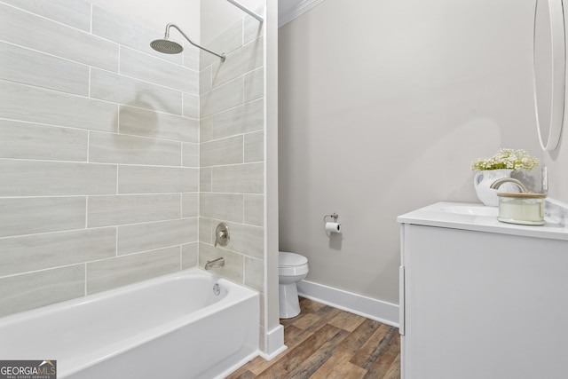 full bathroom with tiled shower / bath combo, toilet, wood-type flooring, crown molding, and vanity