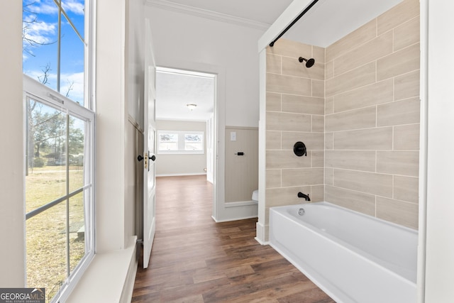 bathroom featuring toilet, hardwood / wood-style floors, crown molding, and tiled shower / bath