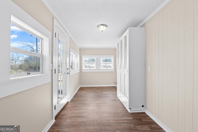 corridor featuring a wealth of natural light, crown molding, and wood walls