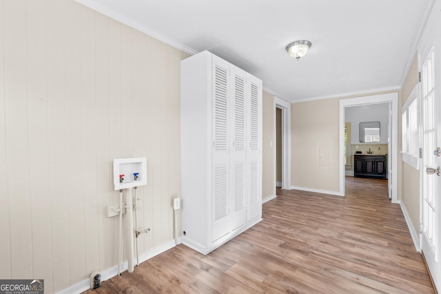 washroom featuring washer hookup, ornamental molding, and light hardwood / wood-style floors