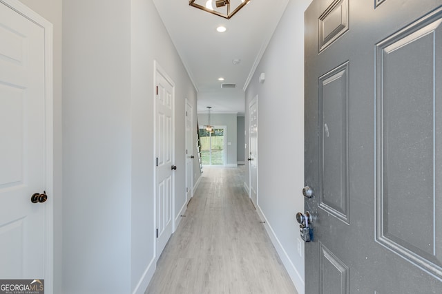 corridor featuring light hardwood / wood-style flooring and crown molding