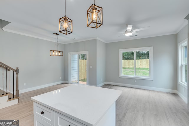 kitchen with ceiling fan, pendant lighting, white cabinetry, and plenty of natural light