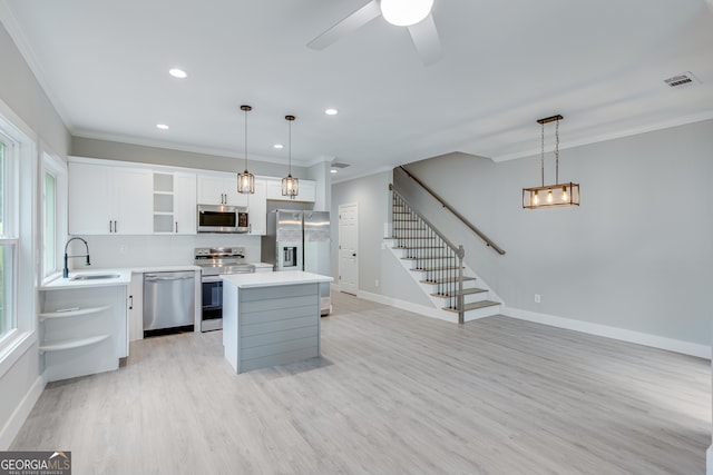 kitchen with white cabinets, stainless steel appliances, sink, and hanging light fixtures