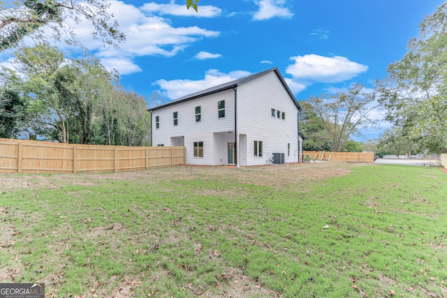 back of property featuring central AC unit and a lawn