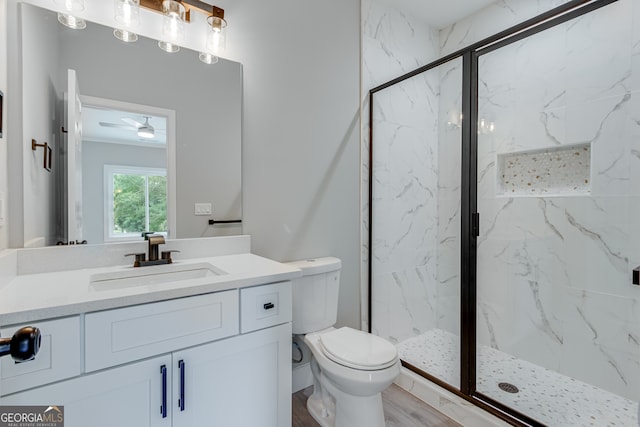 bathroom with toilet, walk in shower, ceiling fan, wood-type flooring, and vanity