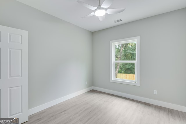 spare room with ceiling fan and light wood-type flooring