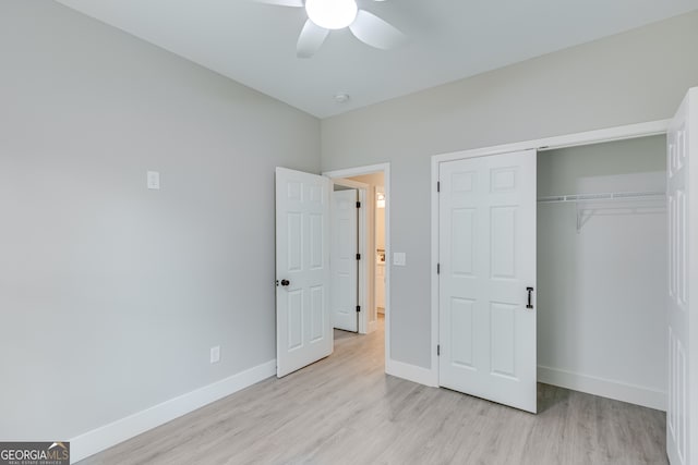 unfurnished bedroom featuring ceiling fan, light hardwood / wood-style floors, and a closet