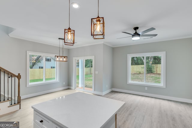 unfurnished living room featuring ornamental molding, light hardwood / wood-style flooring, and ceiling fan with notable chandelier