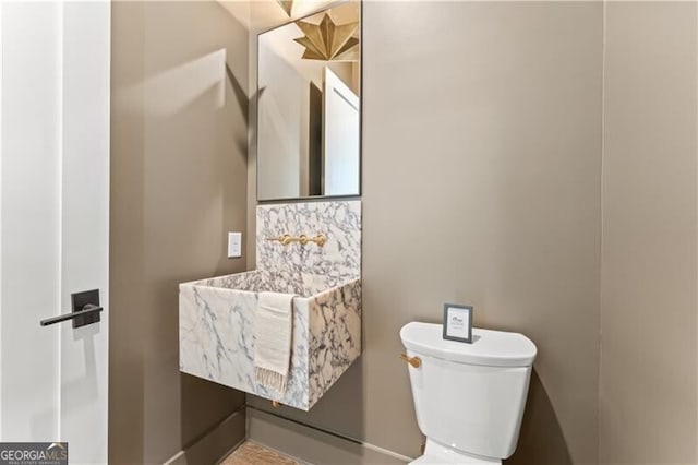 bathroom featuring toilet and decorative backsplash