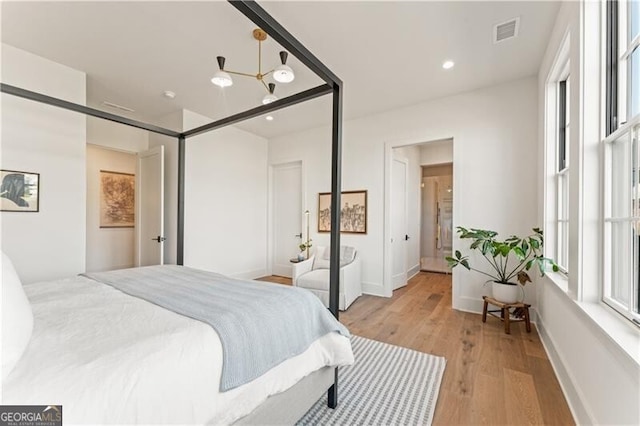 bedroom featuring light wood-type flooring and a chandelier