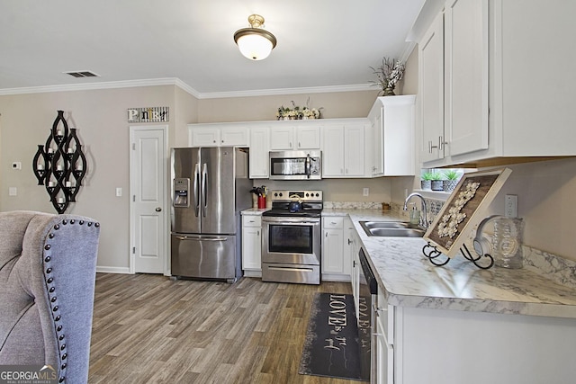 kitchen with appliances with stainless steel finishes, white cabinetry, and sink