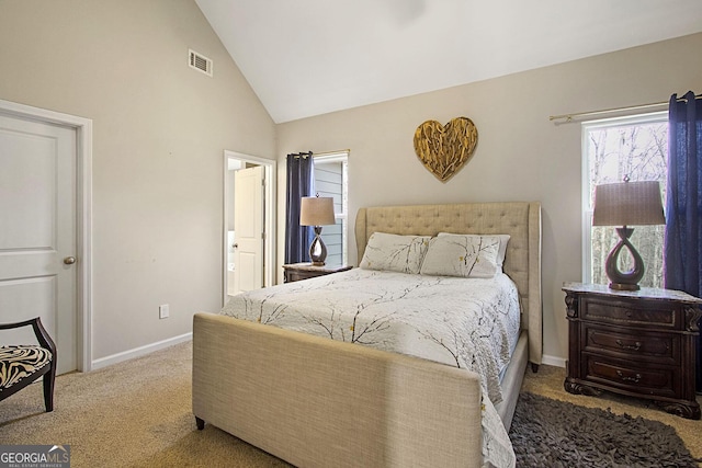 carpeted bedroom featuring ensuite bath and vaulted ceiling