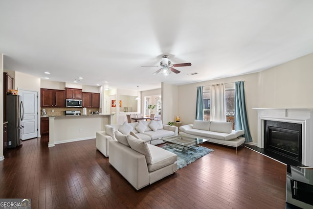 living room with ceiling fan and dark wood-type flooring