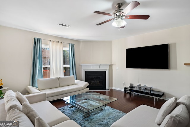 living room featuring ceiling fan and dark wood-type flooring