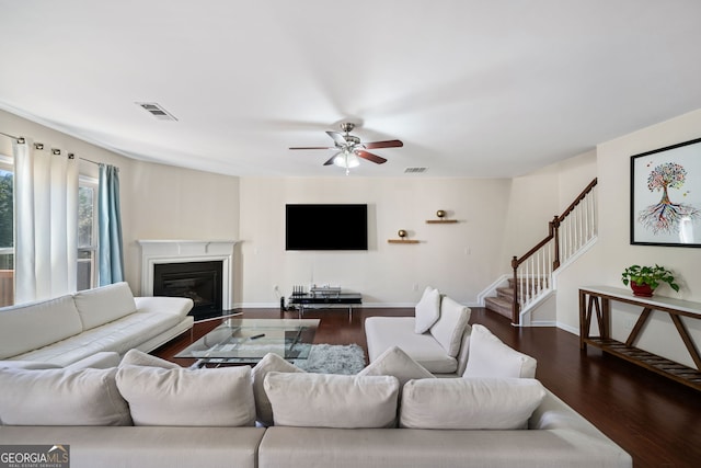 living room featuring ceiling fan and dark hardwood / wood-style floors