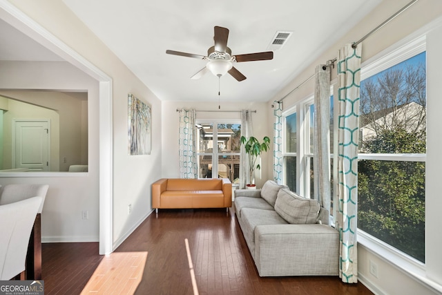 living area featuring ceiling fan and dark hardwood / wood-style flooring