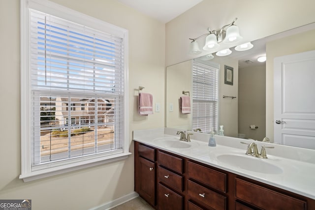 bathroom with vanity, toilet, and a healthy amount of sunlight