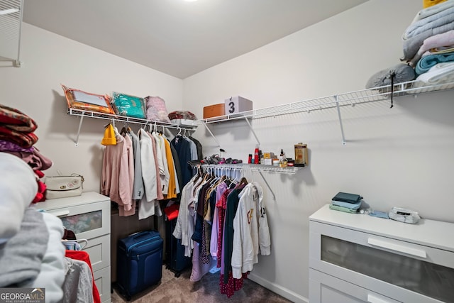 walk in closet featuring dark carpet