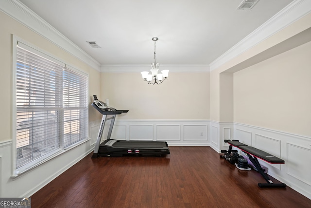 workout area featuring a notable chandelier, crown molding, and dark hardwood / wood-style floors