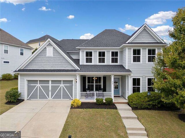 view of front of house featuring a garage, a porch, and a front lawn