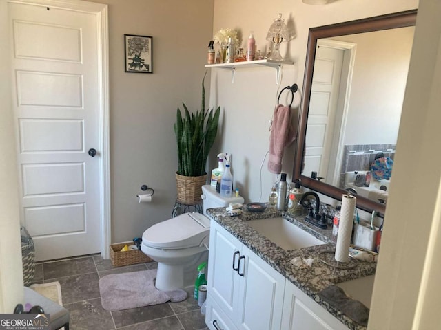 bathroom featuring toilet, tile patterned floors, and vanity