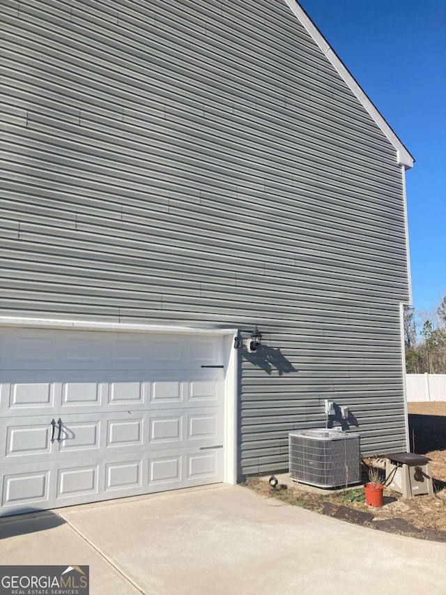 view of property exterior featuring cooling unit and a garage