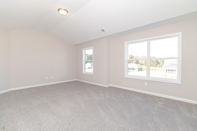 carpeted spare room with vaulted ceiling