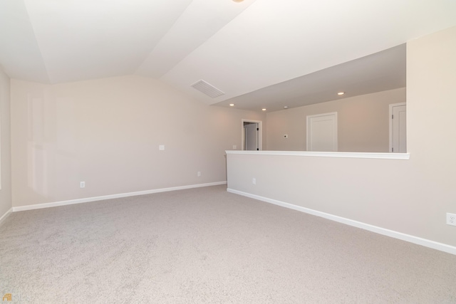 carpeted spare room with lofted ceiling