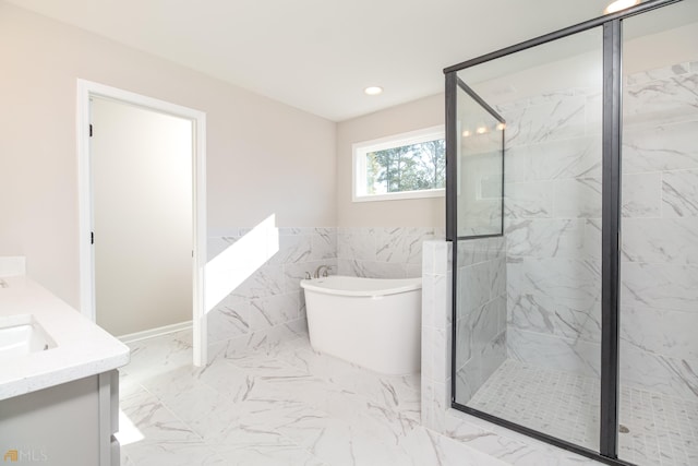 bathroom featuring tile walls, separate shower and tub, and vanity