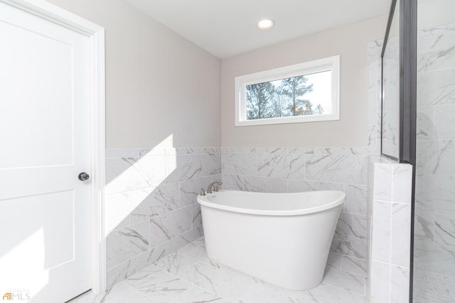 bathroom with tile walls and a washtub