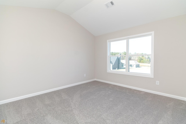 carpeted empty room with lofted ceiling